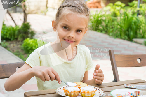 Image of Happy girl coated with confectionery glaze Easter cupcakes