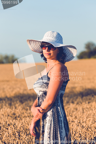 Image of Middle aged beauty woman in wheat field