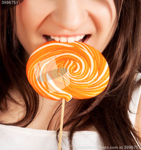 Image of Beautiful girl bites lollipop