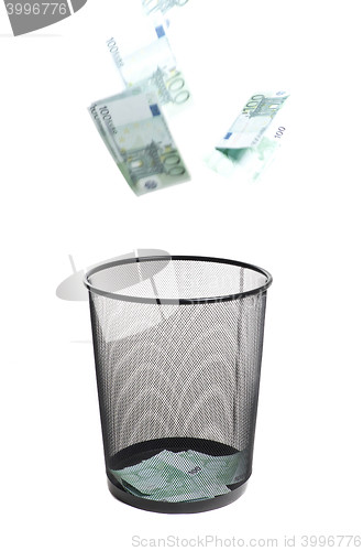 Image of money flying into the trash