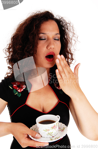 Image of Tired woman holding coffee cup.