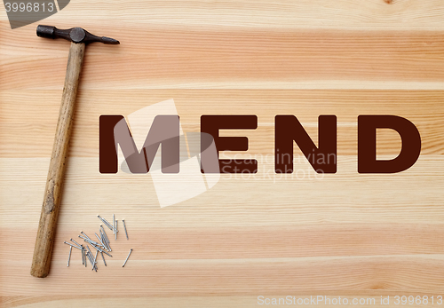 Image of Hammer and panel pins - MEND written on wood