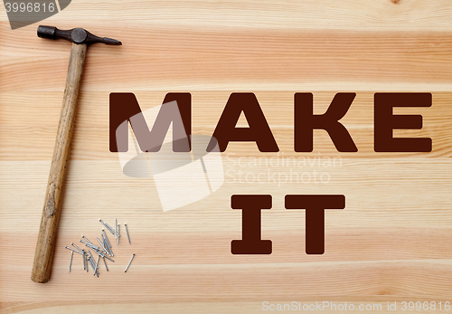 Image of Hammer and nails - MEND IT written on wood