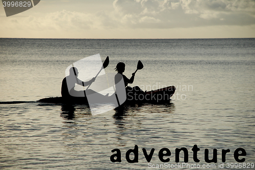 Image of Kayakers silhouetted on the ocean, ADVENTURE as concept text