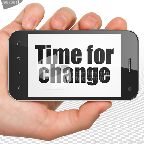 Image of Time concept: Hand Holding Smartphone with Time for Change on display