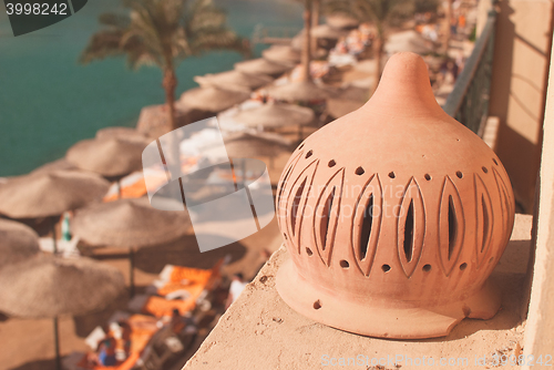 Image of sunny beach with umbrellas and sunbeds on the sea