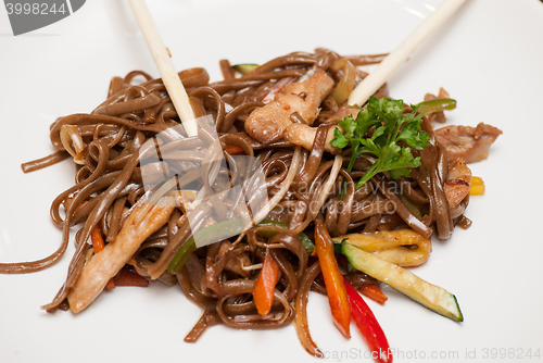 Image of buckwheat noodles with vegetables and sticks isolated on white