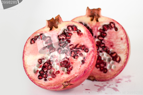 Image of two halfs ripe pomegranate fruit isolated on white background cutout