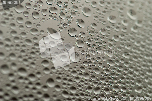 Image of close-up of water drops on the gray background with town reflection