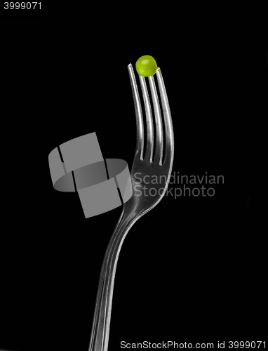 Image of Fresh green peas on a silver fork