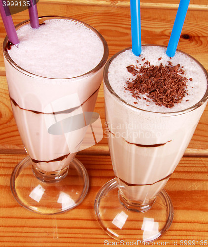 Image of two cocktails with straw on wooden background