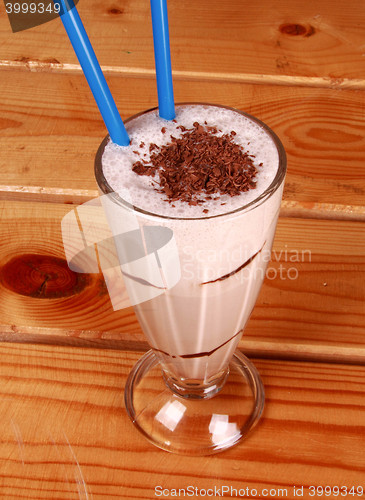 Image of Milk cocktail and straw in goblet with chocolate