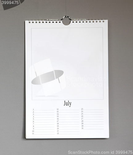 Image of Simple old birthday calendar hanging on a grey wall - July