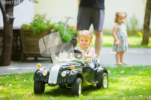 Image of The little baby girl playing at car