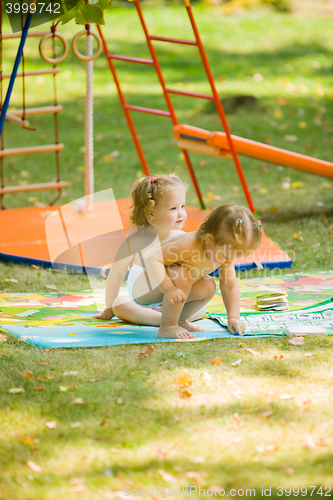 Image of The two little baby girls playing at outdoor playground