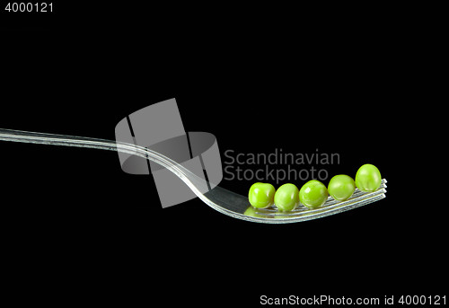 Image of Fresh green peas on a silver fork