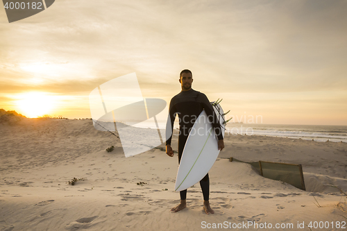 Image of A surfer with his surfboard 