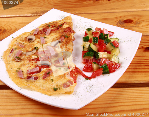 Image of Omelet with prosciutto ham and rocket salad.