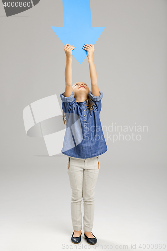Image of Girl holding a big blue arrow