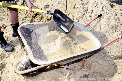 Image of Working ship shovel sand in the construction truck to transport