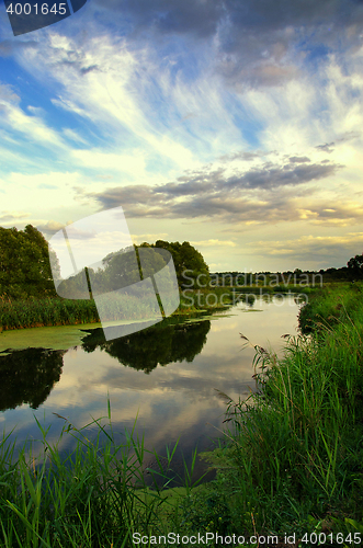 Image of Summer landscape with the sky and clouds reflecting in the river