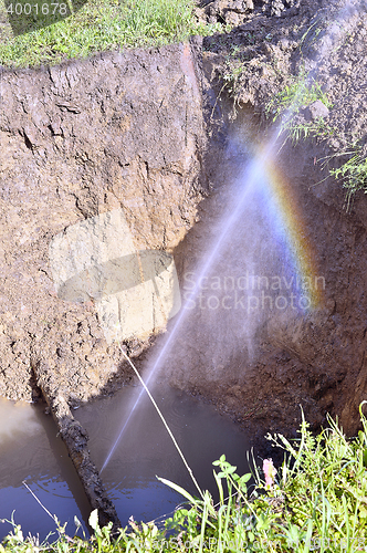 Image of The water jet in the form of leakage in the damaged metal pipe at the production site