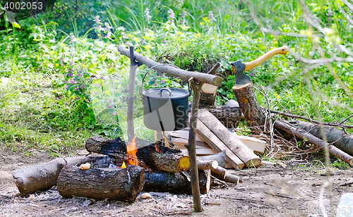 Image of Tourist pot of water hanging over a fire of wood in the Camping