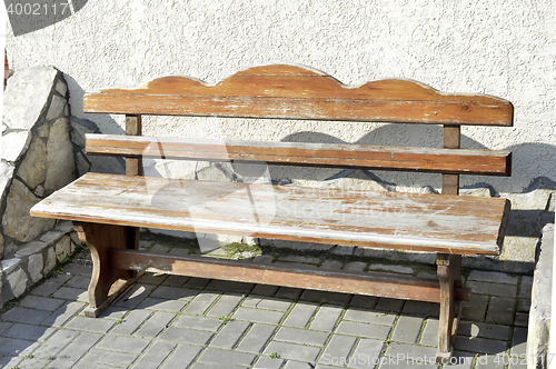 Image of Old wooden vintage empty bench standing on an open paved area