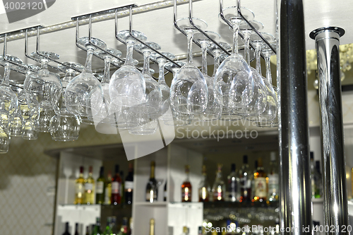 Image of A number of washed glasses hung to dry in the bar