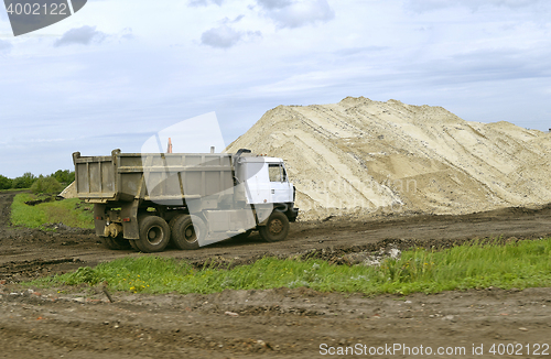 Image of  Yellow excavator working digging in sand quarry