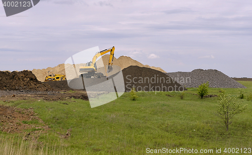 Image of  Yellow excavator working digging in sand quarry