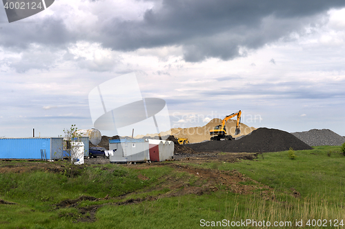 Image of  Yellow excavator working digging in sand quarry