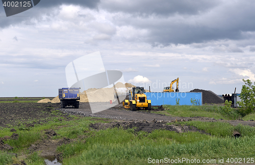 Image of  Yellow excavator working digging in sand quarry