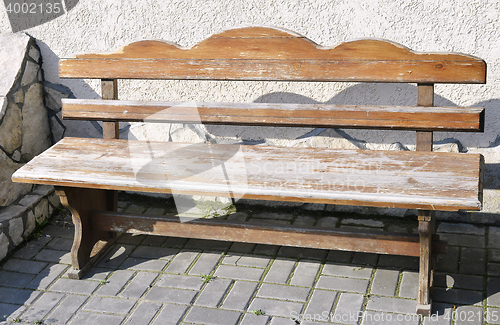 Image of Old wooden vintage empty bench standing on an open paved area