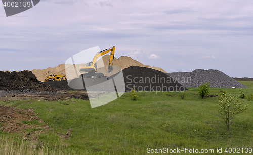 Image of  Yellow excavator working digging in sand quarry