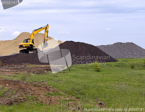 Image of  Yellow excavator working digging in sand quarry