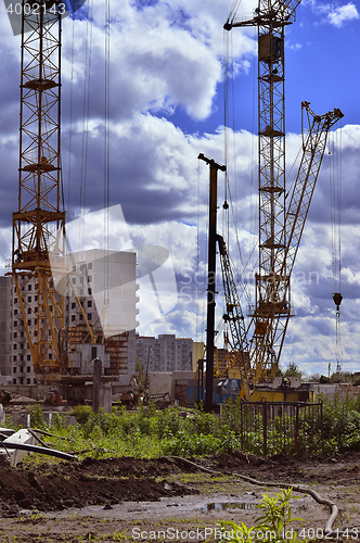 Image of  Construction site with cranes on sky background