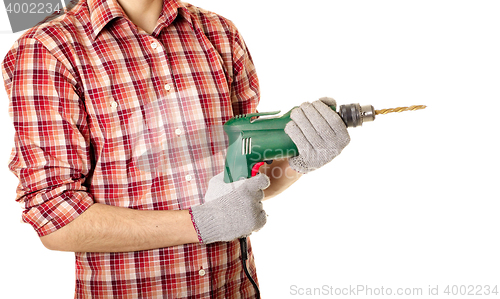 Image of hands handling an electric drilling machine