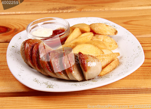 Image of grilled sausages with French fries and ketchup