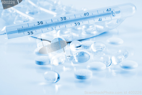 Image of Pills and thermometer in blue tone