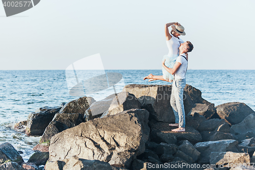 Image of Happy young romantic couple relaxing on the beach and watching the sunset