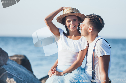 Image of Happy young romantic couple relaxing on the beach and watching the sunset