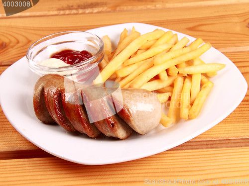 Image of grilled sausages with French fries and ketchup