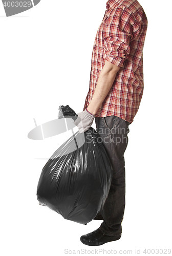 Image of Man holding black plastic trash bag in his hand