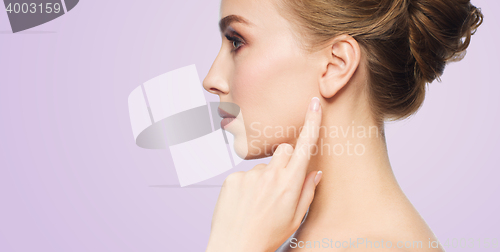 Image of beautiful woman pointing finger to her ear