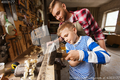 Image of father and son with hammer working at workshop