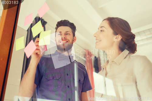 Image of creative team with stickers on glass at office