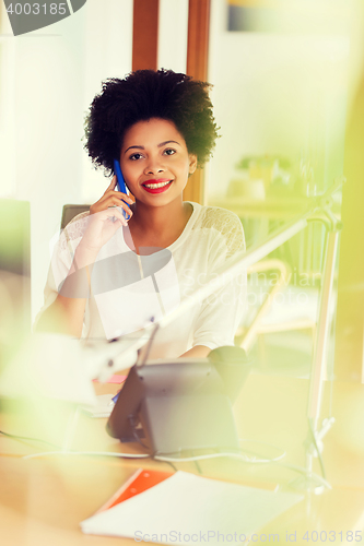 Image of businesswoman calling on smartphone at office