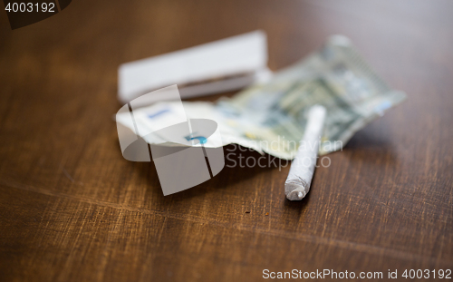 Image of close up of marijuana joint and money