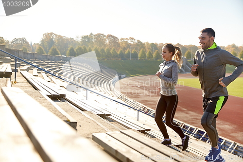 Image of happy couple running upstairs on stadium